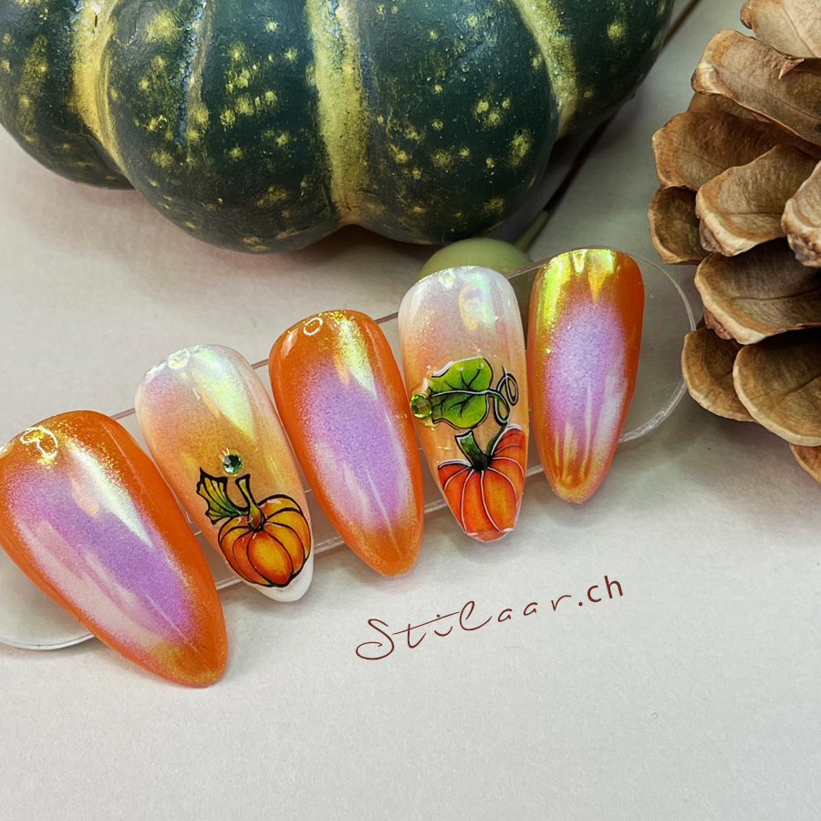 Orange Ombre Nageldesign, verziert mit Nagelstickern und Steinen. Mit Kürbis Motiven.